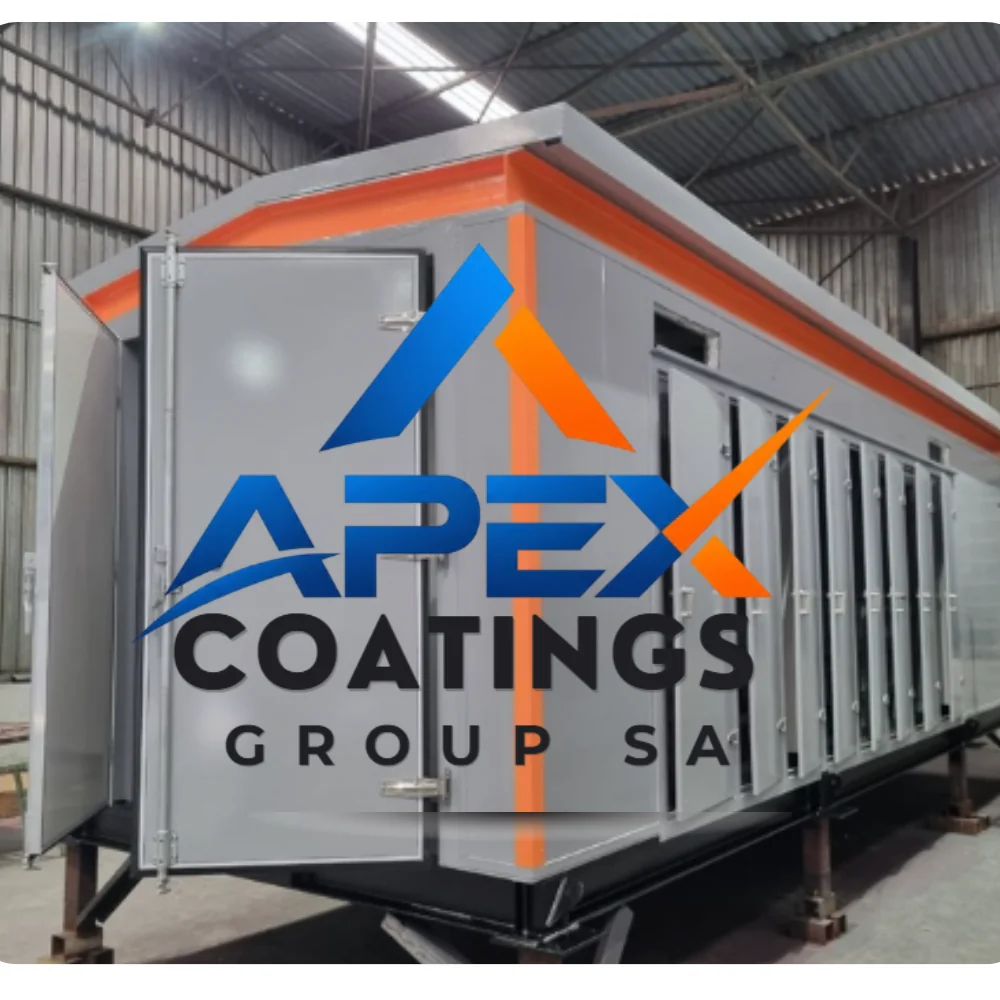 Industrial factory workers applying protective coating to large metal surfaces in a manufacturing facility